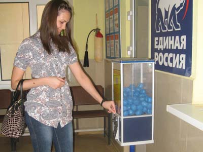 Пациентка поликлиники покупает бахилы в автомате, размещённом в холле больницы Пациентка поликлиники покупает бахилы в автомате, размещённом в холле больницы